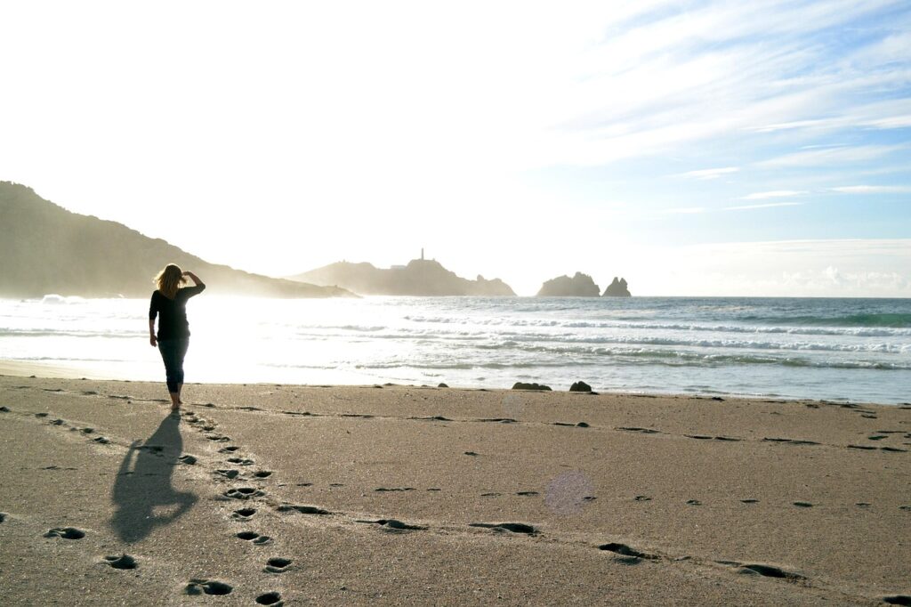 a woman walking on the beachfront during daytime